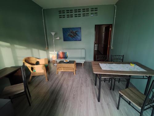 a living room with a table and chairs at Flower Apartment on the beach in Phra Ae beach