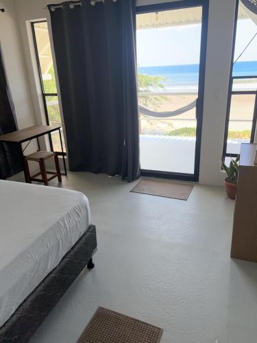 a bedroom with a bed and a view of the beach at Stella Mar Oceanfront Hotel in Popoyo
