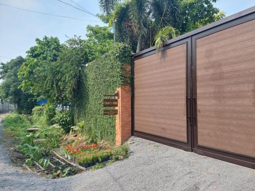 a fence with a wooden gate and a garden at Thao’s Villa in Ho Chi Minh City