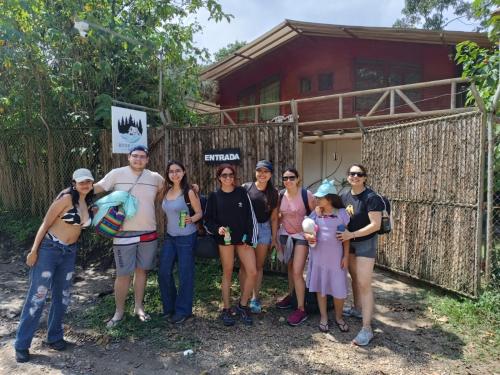 a group of people standing in front of a house at River Song's Hotel in Mindo