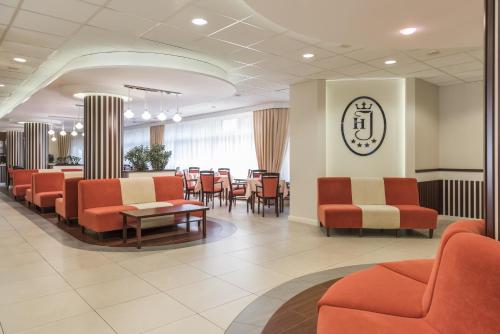 a waiting room with orange chairs and a table at Hotel Justyna in Kraków