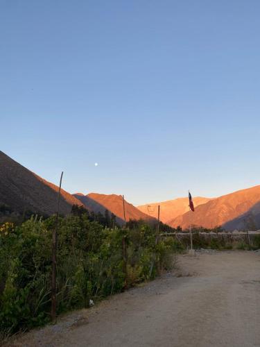 a dirt road with a fence and mountains in the background at DIAGUITAS, VICUÑA, VALLE DEL ELQUI in Diaguita