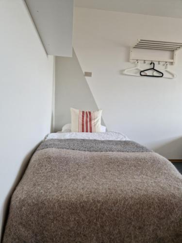 a bed in a white room with a window at Hótel Hvítserkur in Hvammstangi