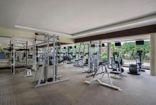 a gym with several treadmills and elliptical machines at Loman Park Hotel Yogyakarta in Yogyakarta