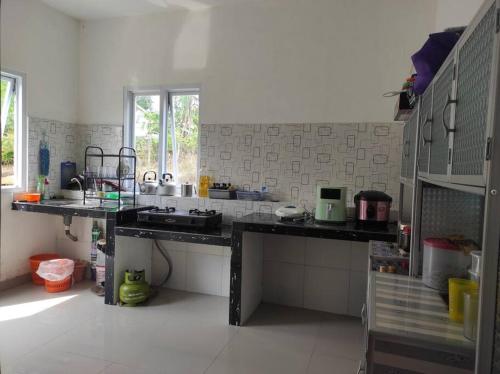 una cocina con encimeras negras en una habitación en Villa BNA Curug Nangka Taman Sari Bogor, en Cibeunjing