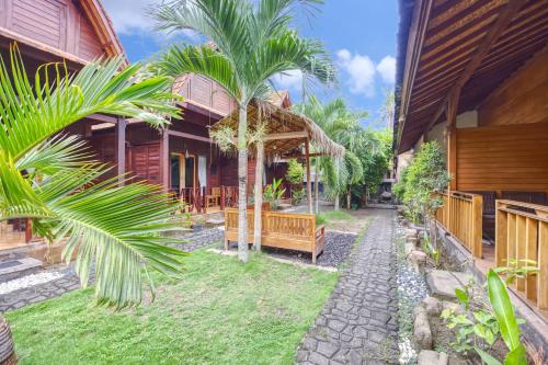 un cortile di una casa con palme e un sentiero di Ba Bar Cottage Penida a Nusa Penida