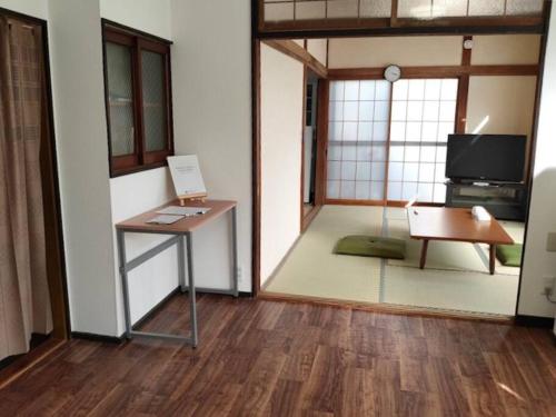 小山市にある【小山駅徒歩7分】みんなで宅飲み！貸切一軒家ニシグチノイエ wifi有、銭湯近くのテーブル、椅子、テレビが備わる客室です。