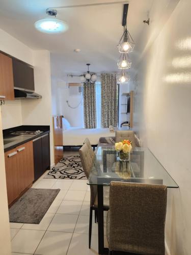 a kitchen and living room with a table and chairs at NORTHPOINT CONDO Free Airport Pick Up for 3 nights stay or more in Davao City