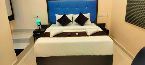 Schlafzimmer mit einem großen Bett mit blauem Kopfteil in der Unterkunft HOTELPEACOCKINN in Visakhapatnam