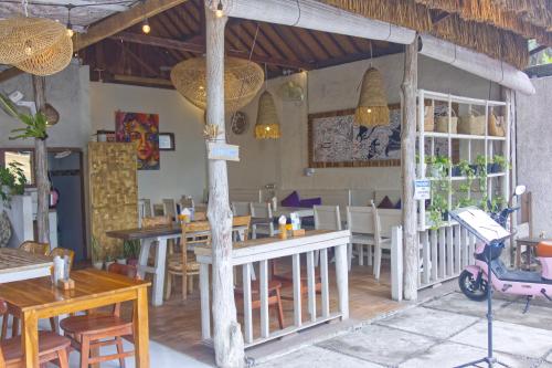 un ristorante con tavoli e sedie in una stanza di Ba Bar Cottage Penida a Nusa Penida