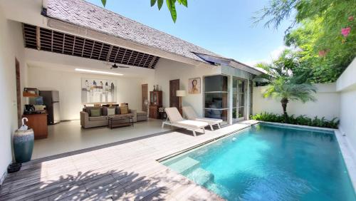 a villa with a swimming pool and a living room at The Decks Bali in Legian