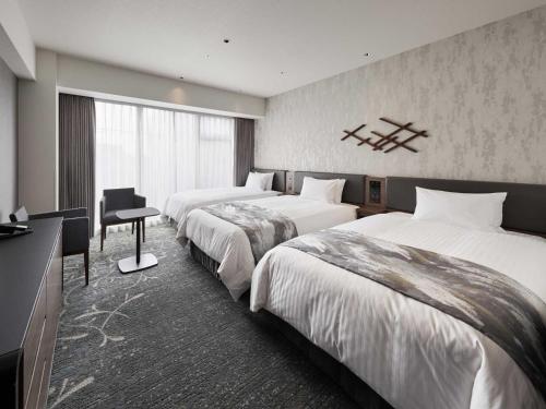 京都市にあるホテルヴィスキオ京都 by GRANVIAのベッド2台とデスクが備わるホテルルームです。