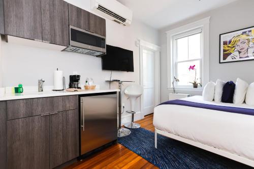 a bedroom with a king sized bed and a kitchen at A Stylish Stay w/ a Queen Bed, Heated Floors.. #26 in Brookline