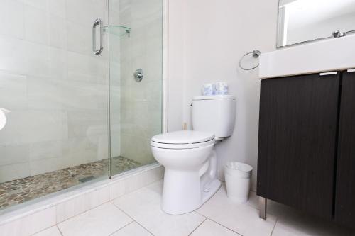 a bathroom with a toilet and a glass shower at A Stylish Stay w/ a Queen Bed, Heated Floors.. #26 in Brookline