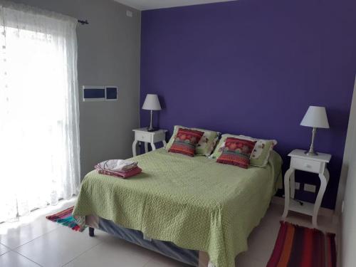una camera con un letto con una parete viola di Hermoso DPTO Turistico. a Destilería Chachapoyas