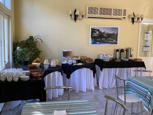 um quarto com duas mesas com toalhas de mesa brancas e pretas em Solanas Termas de Dayman em Termas del Daymán