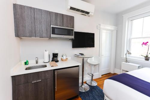 a small kitchen with a sink and a bed at A Stylish Stay w/ a Queen Bed, Heated Floors.. #36 in Brookline