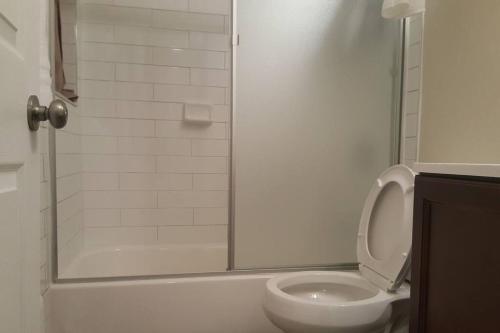 a bathroom with a shower with a toilet and a sink at Beautiful New 4 Bedroom 3 Bath Family Home Nr Howard U Downtown NW DC in Washington