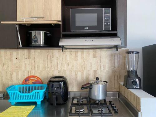 a kitchen with a stove top with a microwave at Apartamento central in Apartadó