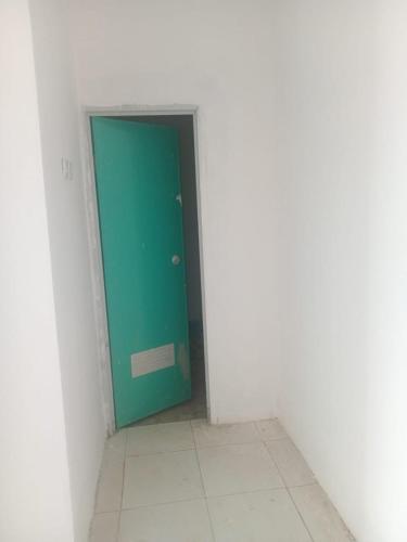 Una puerta verde en una habitación blanca con suelo de baldosa. en PERMATA HOMESTAY, en Cibeker