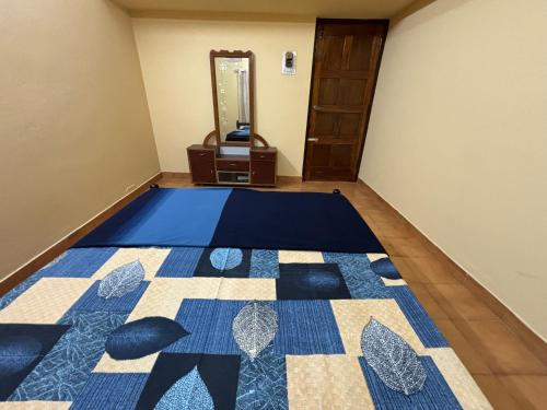 a bedroom with a blue and white quilt on the floor at Kokaris Coorg Homestay in Kushālnagar