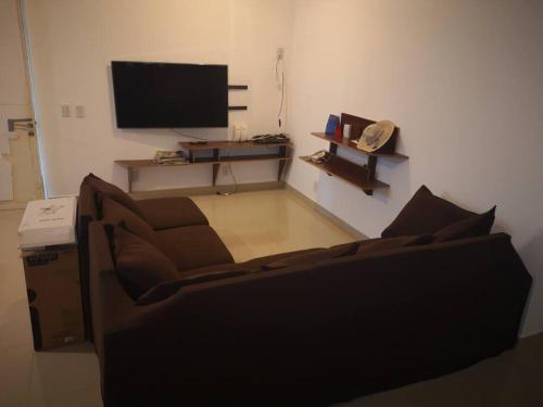 sala de estar con sofá y TV de pantalla plana en Casa cero stress, en Salto