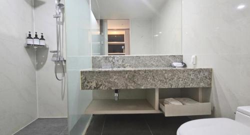 a bathroom with a sink and a shower and a toilet at Air City Hotel Corp in Jeju