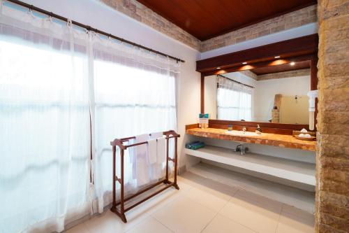 a bathroom with a sink and a mirror at Villa Almarik Resort in Gili Trawangan