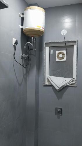 La salle de bains est pourvue d'une lumière et d'un miroir mural. dans l'établissement Hari om PG, à New Delhi
