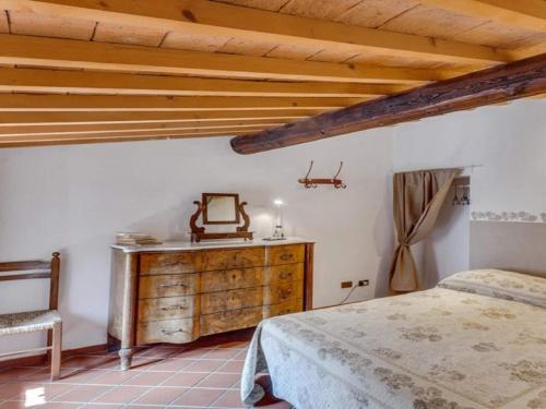 ヴォルテッラにあるHoliday Home in Volterra with Pool and Terraceのベッドルーム1室(ベッド1台、木製ドレッサー付)