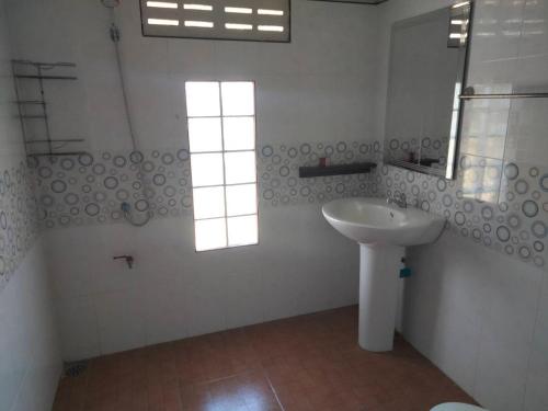 a white bathroom with a sink and a window at Bang Hon Homestay in Ko Yao Noi