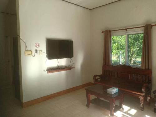 ein Wohnzimmer mit einem Flachbild-TV an der Wand in der Unterkunft Bang Hon Homestay in Ko Yao Noi