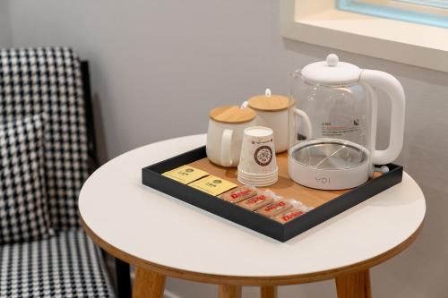 a tray with a tea kettle and other items on a table at MONO HOTEL in Suwon