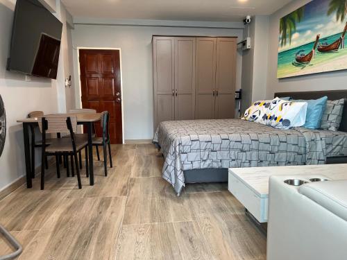 1 dormitorio con cama, mesa y comedor en Patong Vacation Rentals - Studio Apartments - Located in the Heart of Patong with Kitchen, Private Bathroom, Seating Area, 65" Smart TV with Free WIFI, en Patong Beach
