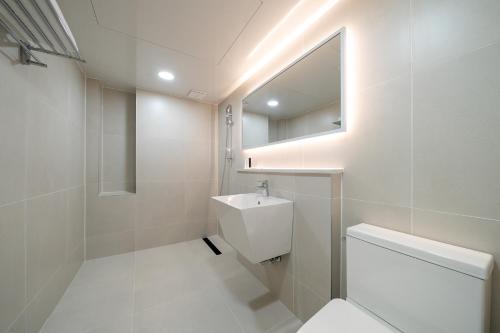a bathroom with a toilet and a sink and a mirror at MONO HOTEL in Suwon