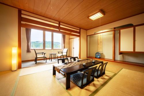 Habitación con mesa y sillas. en Hotel Yutoria Fujisato, en Fujisato