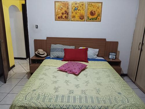 uma cama com um cobertor e duas almofadas em Hóspede se bem e com custo beneficio em Salvador em Salvador