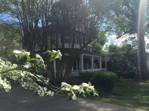 a white house with trees and flowers in front of it at Huffman House Bed & Breakfast in Minden