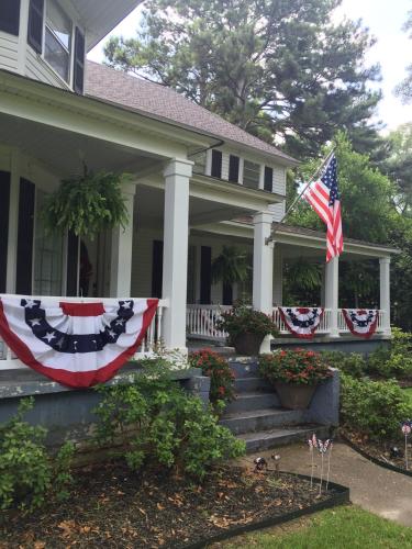 a house with an american flag on the porch at Huffman House Bed & Breakfast in Minden