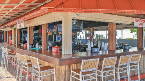 a bar with chairs sitting in front of it at Luxury Beachfront Studio - Private Balcony with Ocean View - Heated Pool - Hot Tub - Tiki Bar - Sauna in Daytona Beach