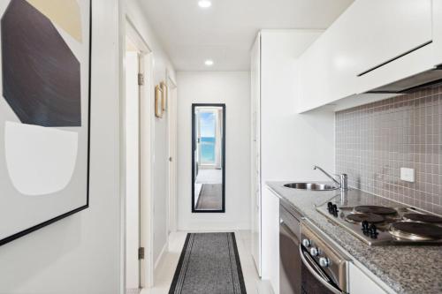a kitchen with a sink and a counter top at Belle Escapes - Beachfront Balcony Glenelg in Glenelg