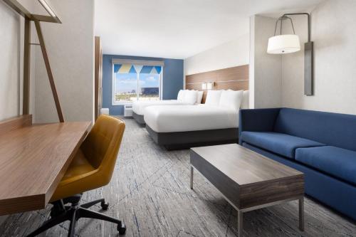 a hotel room with a bed and a blue couch at Holiday Inn Express Las Vegas Stadium Area by IHG in Las Vegas