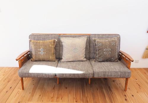 a couch with pillows in a living room at とけとけ山荘 in Fujikawaguchiko
