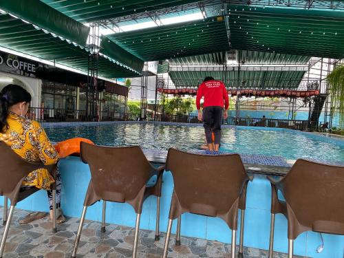 un homme debout au bord d'une piscine dans l'établissement Motel Happy House, à Bạc Liêu