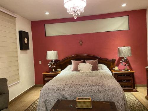1 dormitorio con 1 cama grande y pared roja en CASA ENSUEÑO, en Isla de La Pacanda