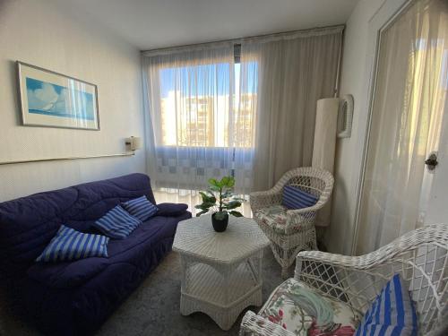 sala de estar con sofá azul y sillas en Appartement Balaruc-les-Bains, 2 pièces, 2 personnes - FR-1-503-49, en Balaruc-les-Bains
