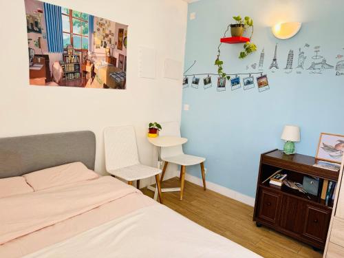 a bedroom with a bed and two chairs and a table at Enjoy Eiffel Tower Views from Home, Only 20 Minutes to Paris Center in Colombes