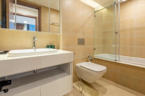 ein Bad mit einem Waschbecken, einem WC und einer Dusche in der Unterkunft NVT Housing - Vinhomes Metropolis Apartment Hanoi in Hanoi