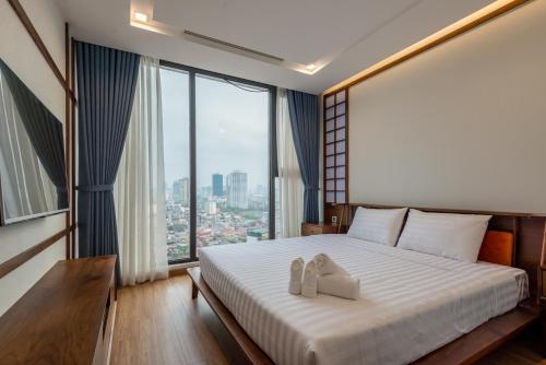ein Schlafzimmer mit einem Bett und einem großen Fenster in der Unterkunft NVT Housing - Vinhomes Metropolis Apartment Hanoi in Hanoi