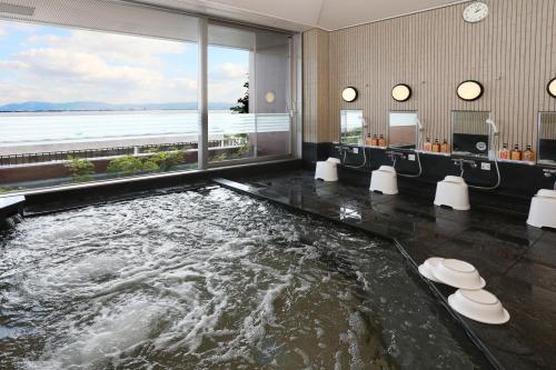 a bath room with a large pool of water at 国家公務員共済組合連合会びわこ保養所（KKRホテルびわこ） in Otsu